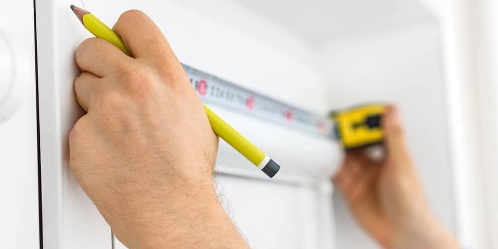 Man installing cassette roller blinds on windows.