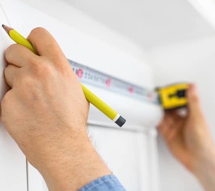 Man installing cassette roller blinds on windows.