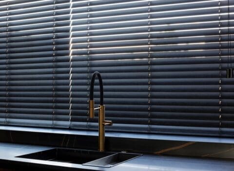 Modern black Venetian blinds in a contemporary kitchen window.
