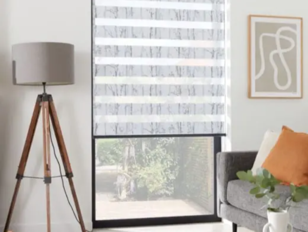 stylish day and night blind with sheer stripes in a modern living room with tripod lamp and grey sofa