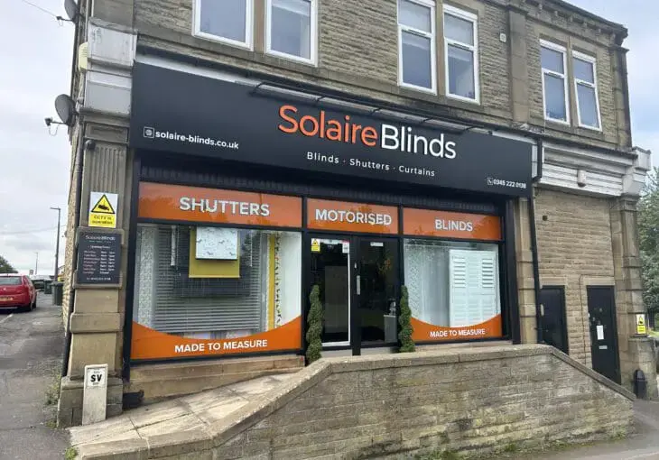 Exterior view of Solaire Blinds’ showroom near Crossgates, featuring the store entrance and displays for shutters, motorised blinds, and made-to-measure designs.
