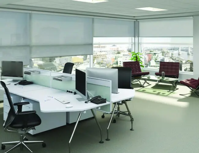 modern open-plan office with white roller blinds and city view through large windows