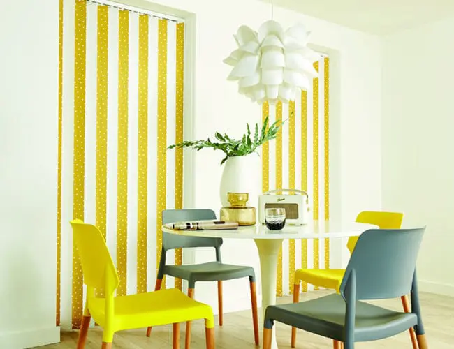 yellow patterned vertical blinds in a bright dining and living space